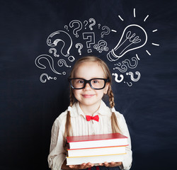 Cheerful child school girl student with stack of book, lightbulb and chalk question marks. Brainstorm, problem and solution concept