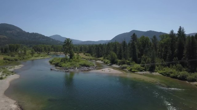 Aerial View Crossing Small Bridge Over River Passing Lonely Tree - Priest River Idaho