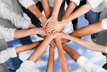 Group of people stacking hands together