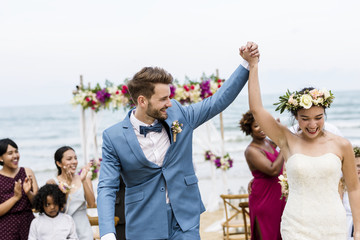 Cheerful newlyweds at beach wedding ceremnoy