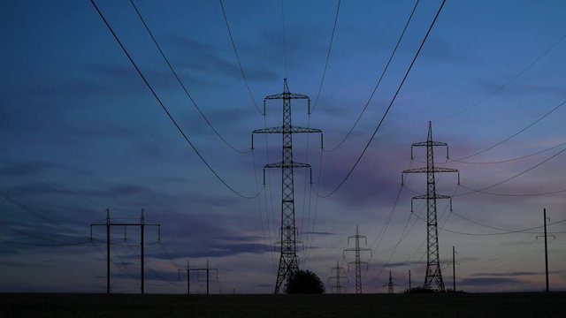 Electricity pylons and the evening sky on the background. Timelapse. 4K