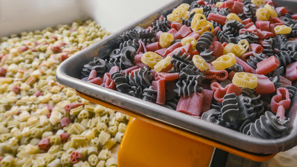 raw pasta lie on the mechanical scales in the store
