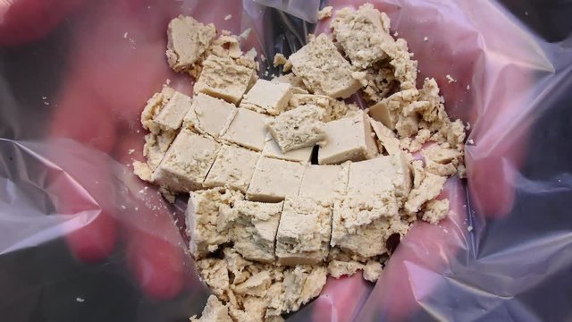 A man holds pieces of Halva and offers the Halva to people