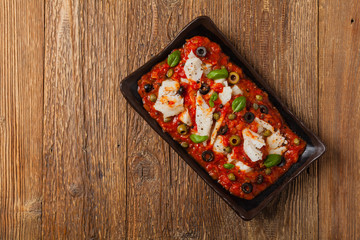 Cod in Italian in tomatoes with olives and capers.