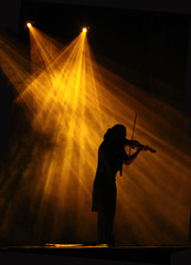 Violin player in the spot light of the stage