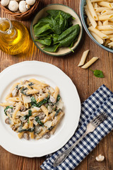 Penne pasta with spinach and mushrooms. Sprinkled with cheese.
