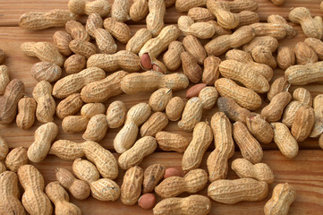 Roasted peanuts on wood texture background.