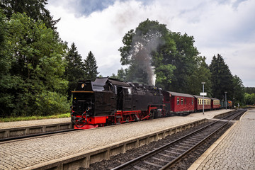Old steam locomotive leaving the train station