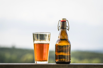 Glass of beer next to a bottle