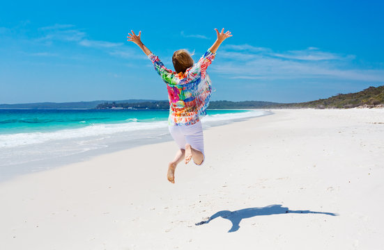 Summertime woman jump for joy beach