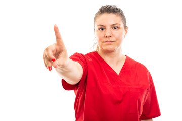 Fototapeta premium Young medical nurse wearing red scrub showing denying gesture.