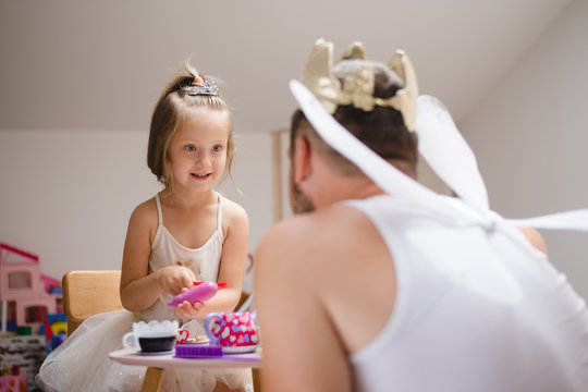 Little daughter and father have fun, dressing in princess costume, daddy makeup
