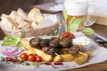  Appetizing vegetables cooked on the grill. Barbecue mushrooms and potatoes.  Tasty snack