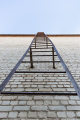 Old brick wall background with a metal staircase going into the sky
