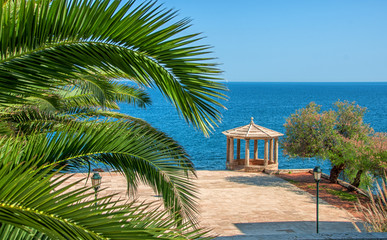 Fototapeta na wymiar Palm leafs against blue sea and alcove. Spain. Sagaro. Mediterranean Sea.