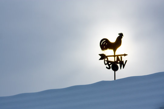 Wetterhahn auf schneebedeckten Bergen