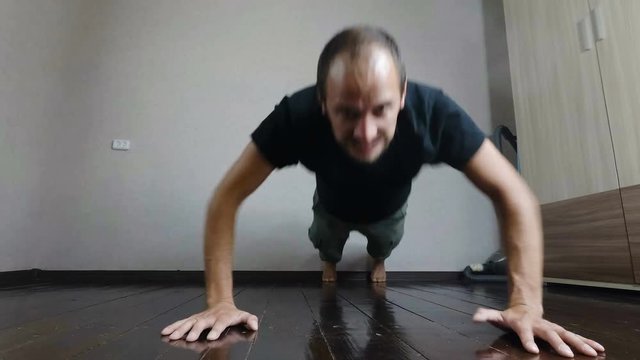 the guy pushed off the floor with a strained tired face. young man trains at home.