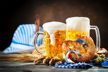Beer mugs and pretzels on a wooden table. Oktoberfest. Beer festival. - obrazy, fototapety, plakaty