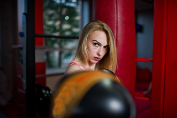 Sexy sport blonde girl punching bag. Fit woman boxing.
