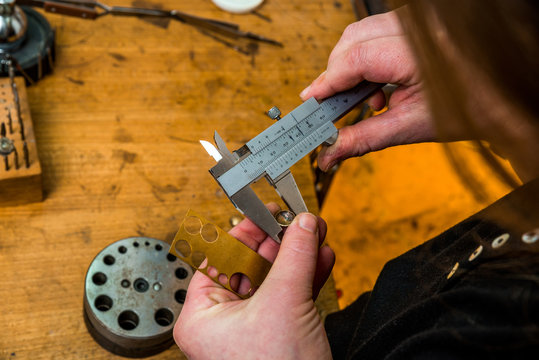 Scaling a jewelry piece with equipment at workshop of goldsmith