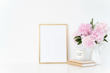 Elegant gold portrait a4 frame mock up with a pink peonies in white jug. Overlay your quote, promotion, headline, or design, great for small businesses, lifestyle bloggers and social media campaigns