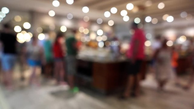 Bokeh, lights, defocused image of people in the restaurant buffet. People are out of focus in the restaurant at the resort.