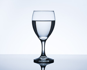 Elegant drinking glass and water. Backlit studio image.