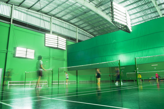 Indoor Badminton Court with Many Players in Motion Blurred