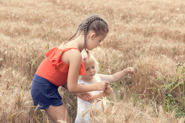 Little children playing in a wheat field