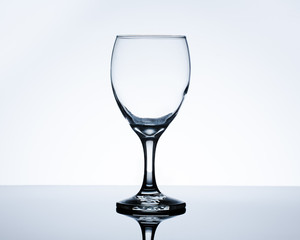 Empty wine glass on table. Backlit studio image.