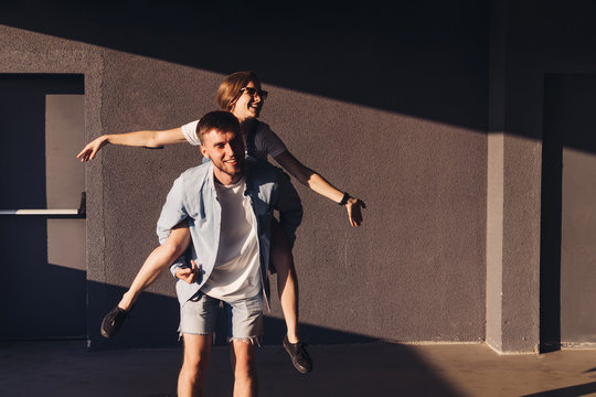 Young couple piggybacking on the parking