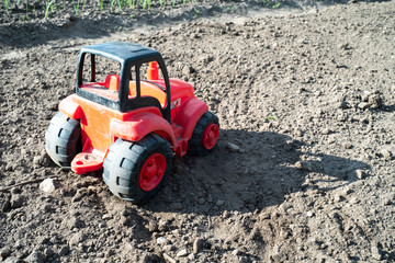 on the field from the soil is a red tractor