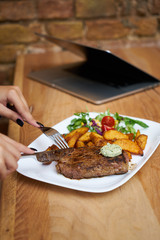 a business girl eats a steak at a restaurant