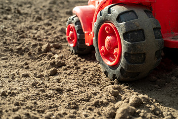 black wheels of the tractor on the field are not sown, the spring field