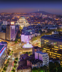 Aerial view of Belgrade Slavia Square, St Sava Temple, Avala Mountain by night panorama with city lights and fountain