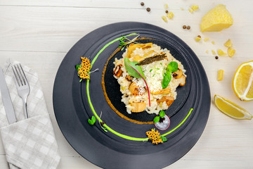 Classic Italian risotto cooked in a vegetable broth with porcini mushrooms and parmesan on a wooden table. Delicious vegetarian Italian cuisine rice meal. Directly above top view shot.