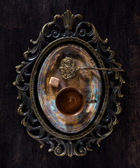 Still life with a cup of coffee and sugar on vintage tray, on wooden background, top view