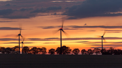 Fototapeta na wymiar turning windfarm rotors with sunset