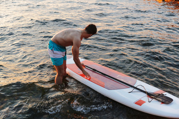 Handsome man kayaking on lake sea.