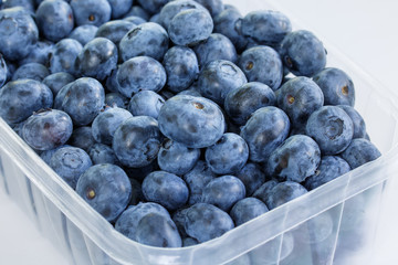Close up of blueberries in a container on white background