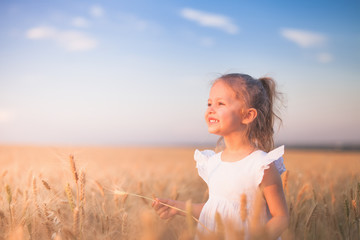 Fototapeta na wymiar Happy Little Girl Outdoor At Wheat Field. End of Summer