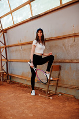 Young sporty girl player with tennis racket on tennis court.