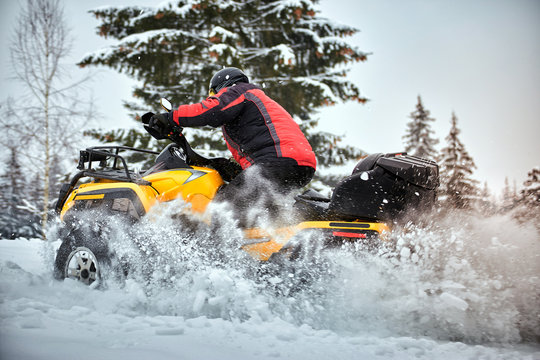 Winter race on an ATV on snow in the forest.