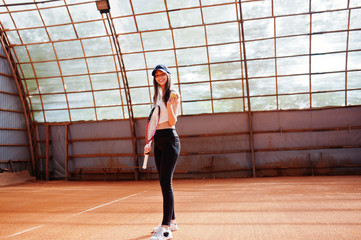 Naklejka na ściany i meble Young sporty girl player with tennis racket on tennis court.