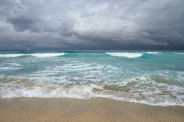 Fototapeta na wymiar coast of the Atlantic Ocean during a storm, waves on the sand, motor yacht on the horizon, low clouds, Varadero, Cuba