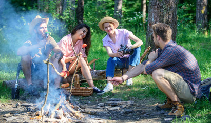 Hikers sharing impression of walk and eating. Weekend hike. Picnic with friends in forest near bonfire. Company having hike picnic nature background. Tourists with camera relaxing checking photos