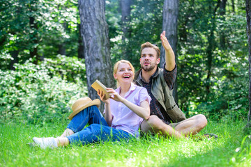 Romantic couple students enjoy leisure looking upwards observing nature background. Couple in love spend leisure in park or forest. Romantic date at green meadow. Couple soulmates at romantic date