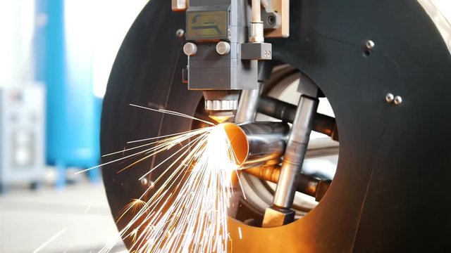 Grinding machine is cutting the pipe and a lot of sparks flying.