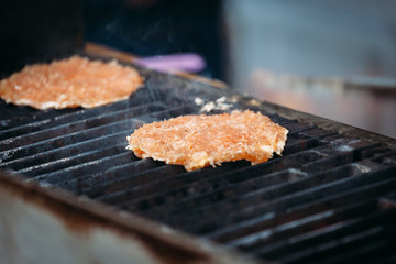 a hamburger cutlet is cooked on the grill