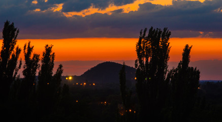 Landscape with dramatic light - beautiful golden sunset with saturated sky and clouds.